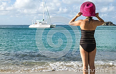 Woman with Pink Straw Hat Looking at a Catamaran