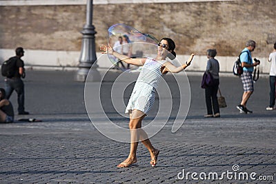 Woman playing hugging a big soap bubble