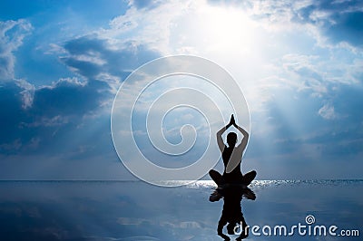 Woman practicing yoga, silhouette on the beach at sunset