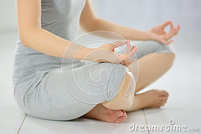 Woman practicing yoga, Sitting In A Lotus Pose And Meditating