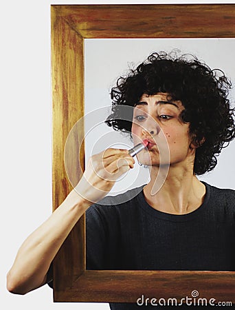 Woman put lipstick on through picture frame