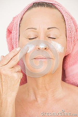 Woman putting cream on face