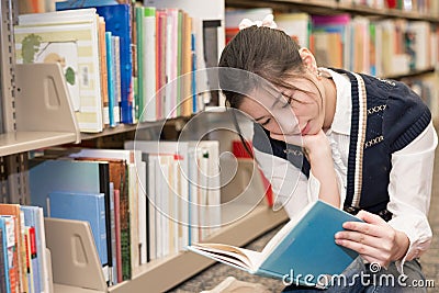 Woman reading a book near bookshelf