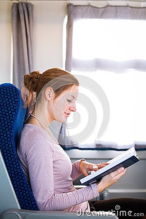 Woman reading a book while on a train