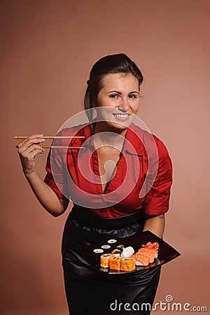 Woman in red dress with chopsticks and plate of sushi