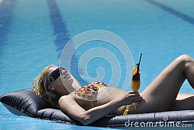 Woman relax and drink coctail at swimming pool
