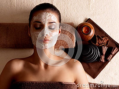 Woman relaxing with facial mask on face at beauty salon