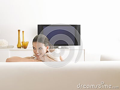 Woman Relaxing On Sofa In Living Room