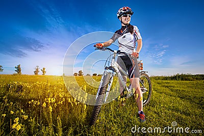 Woman is riding bicycle outside in the field