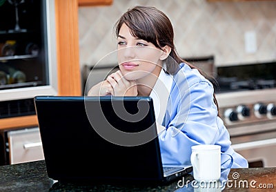 Woman in robe using laptop computer over coffee