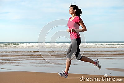 Fitness woman running on beach