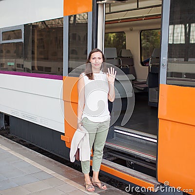 Woman saying goodbye in front of train