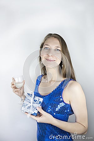Woman in sequins holding gift and glass of wine
