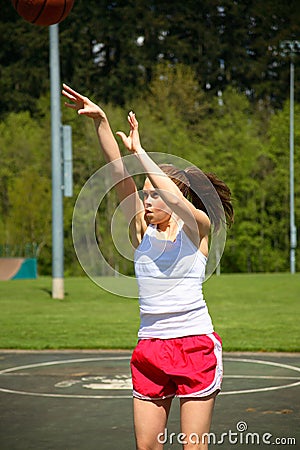 Woman shooting basketball
