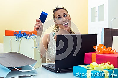 Woman shopping online with laptop looking your credit card