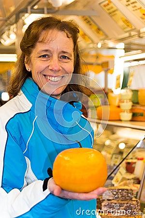 Woman showing round cheese