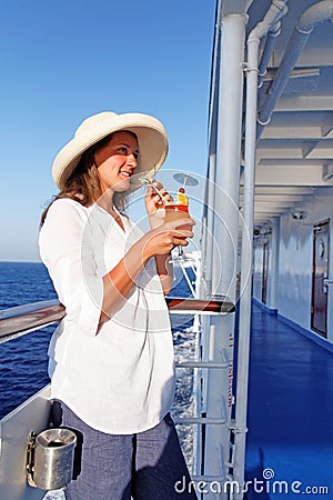 A woman sipping a cocktail happy traveling