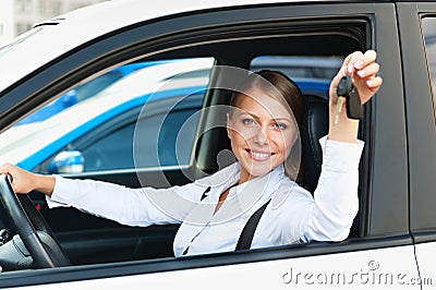 Woman sitting in car and showing the car keys