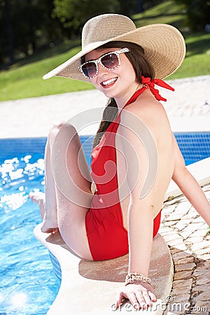 Woman Sitting On Edge Of Swimming In Pool