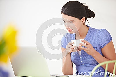 Woman Sitting At Table Using Laptop Computer