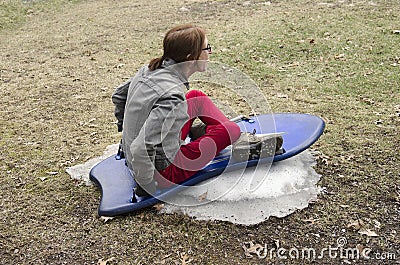 Woman sledding on small amount of snow