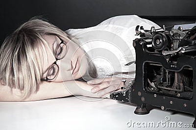 Woman sleeping with glasses and old typewriter