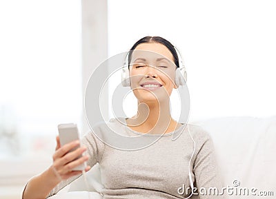 Woman with smartphone and headphones at home