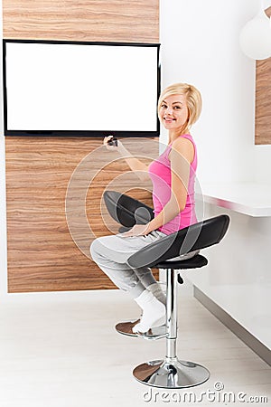 Woman smile watching tv rmote control channel