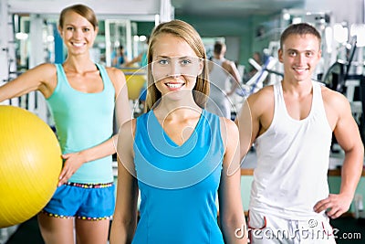 Woman smiling in front of a group of gym people