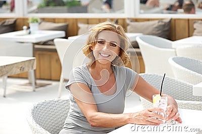 Woman smiling at restaurant with glass of water