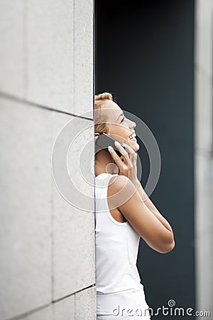 Woman speaking on telephone near office