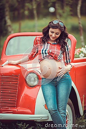 Woman standing in front of retro red car