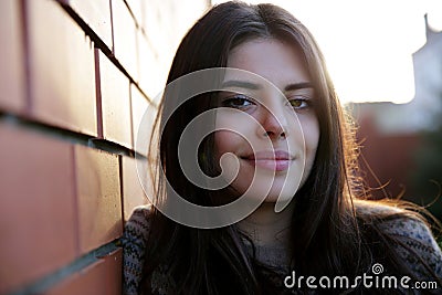 Woman standing near brick wall