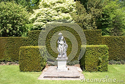 Woman statue. hedges. topiary trees