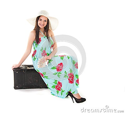 Woman in summer dress with hat and money sitting on a black case