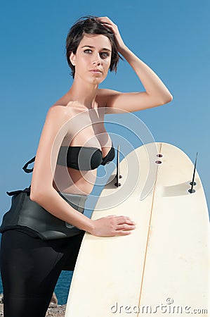 Woman with surfboard under blue sky