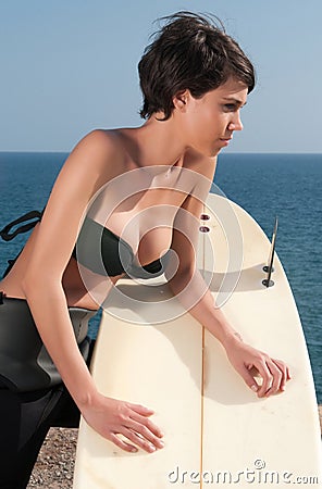 Woman with surfboard under blue sky