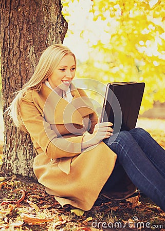 Woman with tablet pc in autumn park