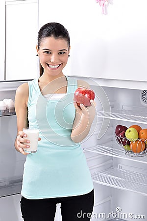 Woman take red apple and milk from fridge