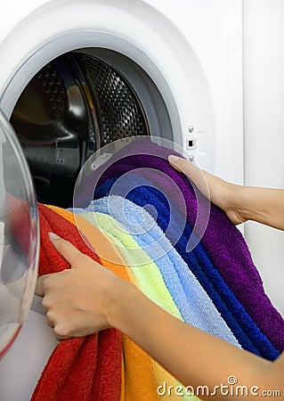 Woman taking color laundry from washing machine