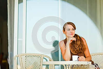 Woman on terrace having cup of coffee