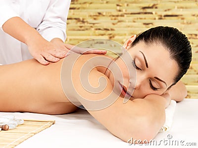 Woman on therapy massage of back in spa salon