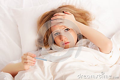 Woman with thermometer sick colds, flu, fever in bed