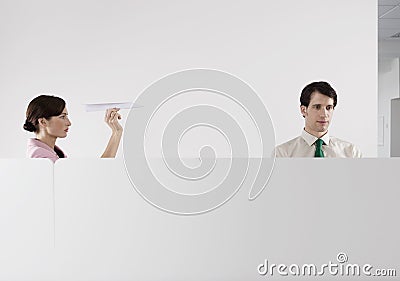 Woman Throwing Paper Aeroplane At Male Colleague