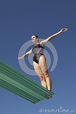 Woman About To Dive Backwards Off A Diving Board