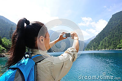 Woman tourist taking photo with smart phone