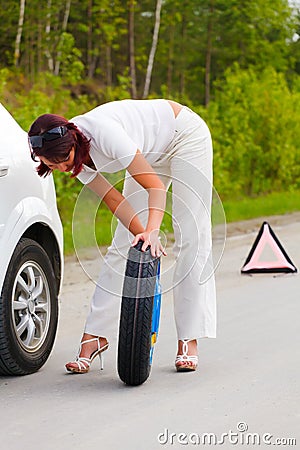 Woman trying to change the wheel