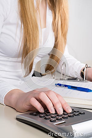 Woman types at a desk calculator