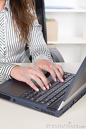 Woman is typing at a notebook