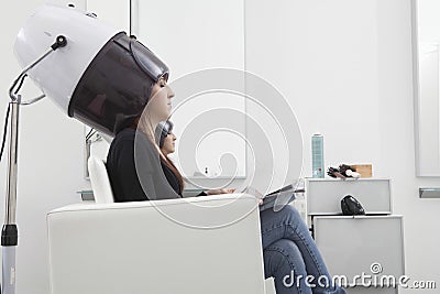 Woman Under Hooded Dryer Machine In Hair Salon